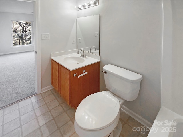 bathroom with toilet, vanity, and baseboards