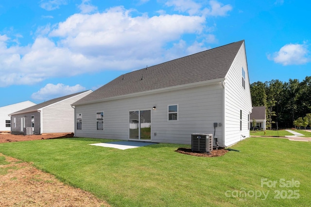 back of property featuring a yard, a patio, roof with shingles, and central AC unit