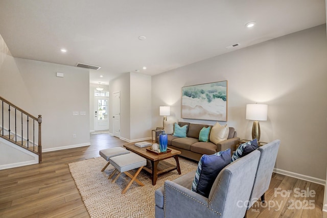 living area with visible vents, recessed lighting, stairway, and wood finished floors