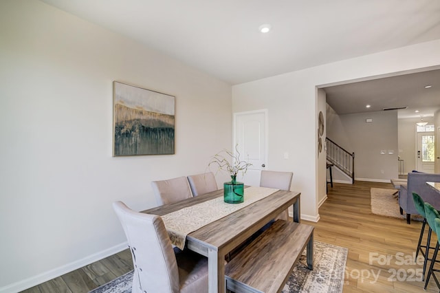 dining room featuring recessed lighting, baseboards, light wood-style flooring, and stairs