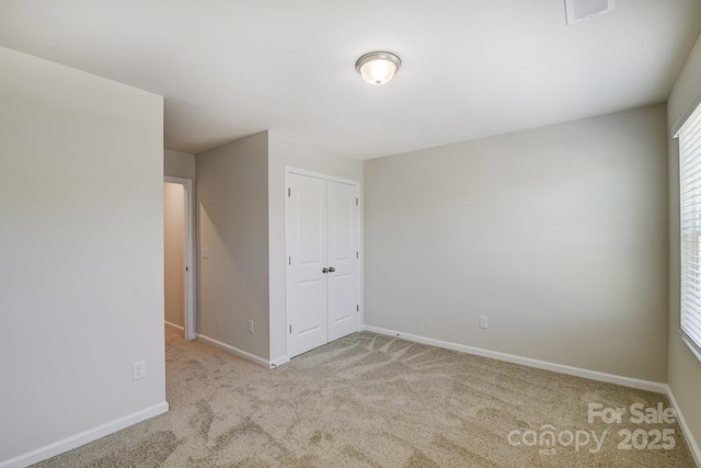 unfurnished room featuring visible vents, carpet floors, and baseboards