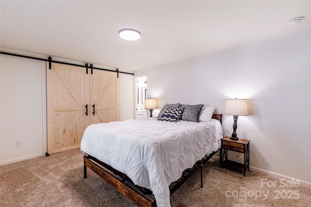 carpeted bedroom with a barn door and baseboards