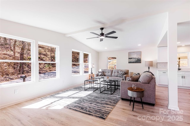 living area featuring a ceiling fan, baseboards, lofted ceiling with beams, light wood-style flooring, and recessed lighting