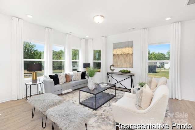 living area featuring recessed lighting, visible vents, baseboards, and wood finished floors