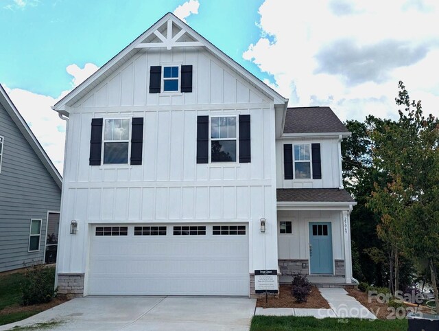 modern inspired farmhouse with board and batten siding, an attached garage, driveway, and a shingled roof