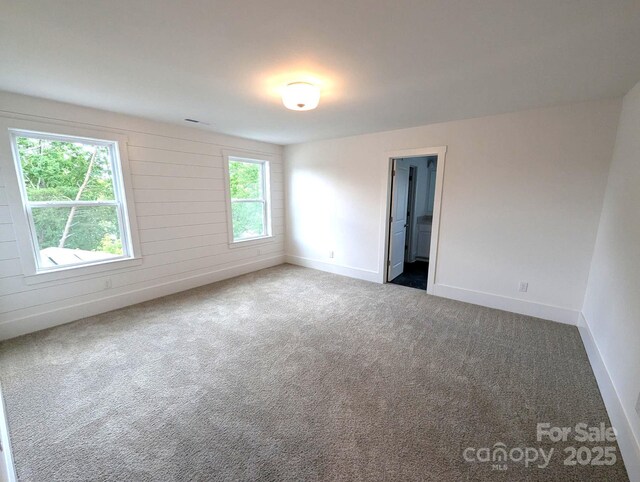 empty room featuring baseboards and carpet flooring