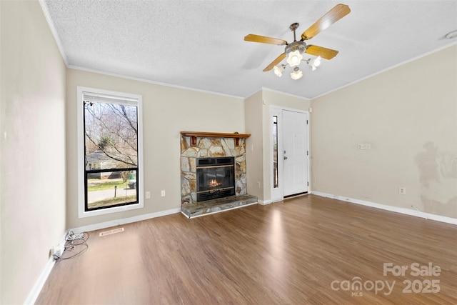 unfurnished living room with crown molding, wood finished floors, visible vents, and a textured ceiling