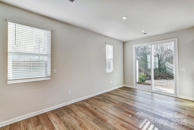 unfurnished room with visible vents, recessed lighting, baseboards, and wood finished floors