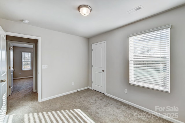 unfurnished bedroom featuring visible vents, baseboards, and carpet floors