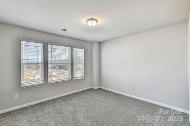 unfurnished room with visible vents, carpet flooring, and baseboards