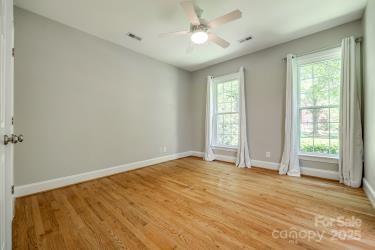 unfurnished room featuring light wood-style flooring, baseboards, and plenty of natural light