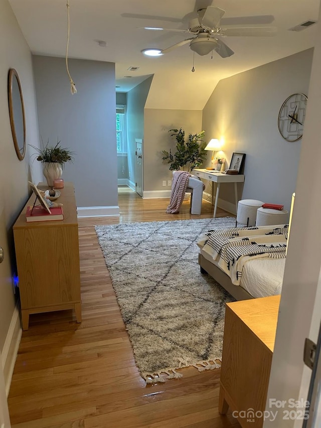 living area with a ceiling fan, baseboards, and wood finished floors