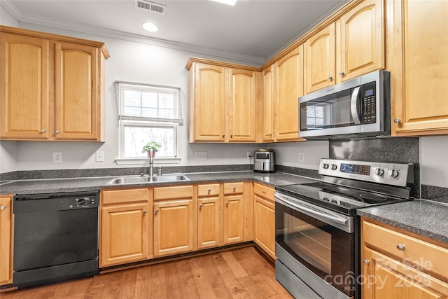 kitchen with visible vents, a sink, dark countertops, appliances with stainless steel finishes, and crown molding