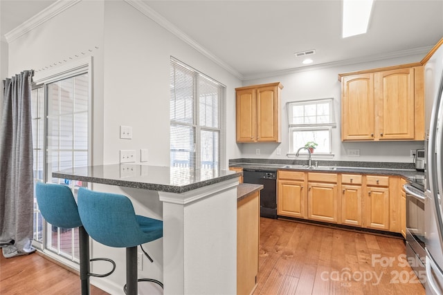 kitchen featuring visible vents, a sink, stainless steel range with electric stovetop, dishwasher, and a kitchen bar