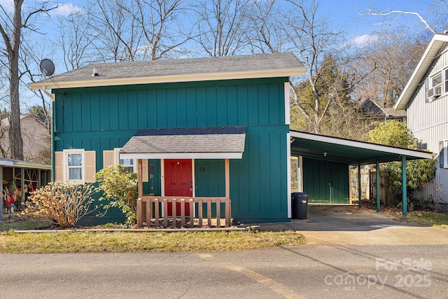 view of front of house with an attached carport, roof with shingles, and driveway