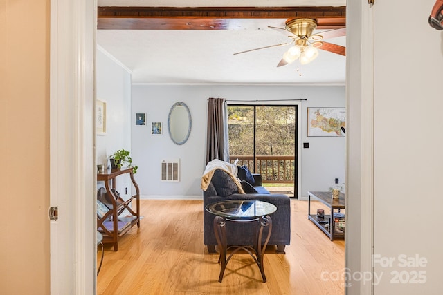 living area featuring visible vents, crown molding, light wood finished floors, baseboards, and ceiling fan