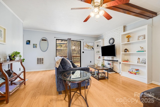 living room featuring light wood-type flooring, visible vents, a ceiling fan, and crown molding