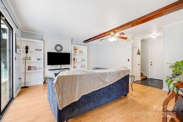 living room featuring crown molding, beamed ceiling, light wood finished floors, and ceiling fan