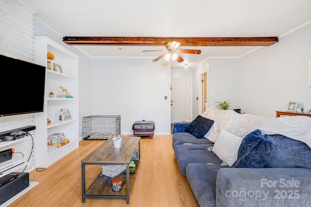 living area with beam ceiling, a ceiling fan, light wood-type flooring, and ornamental molding