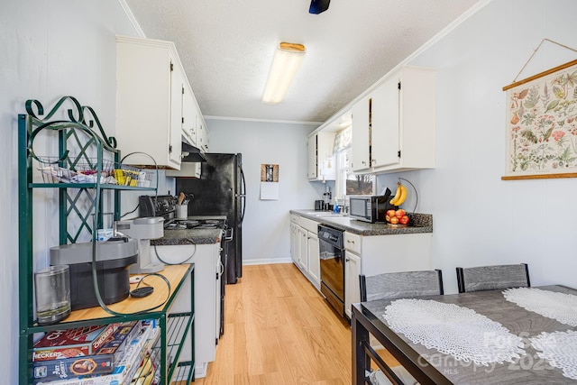 kitchen featuring dark countertops, light wood finished floors, white cabinets, black dishwasher, and stainless steel microwave