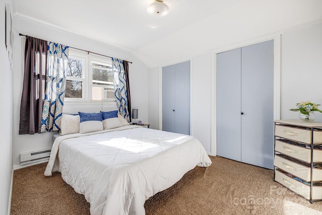 bedroom featuring light carpet, two closets, lofted ceiling, and a baseboard radiator