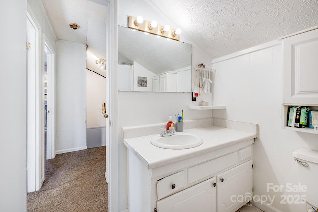 bathroom featuring vanity, lofted ceiling, and a textured ceiling