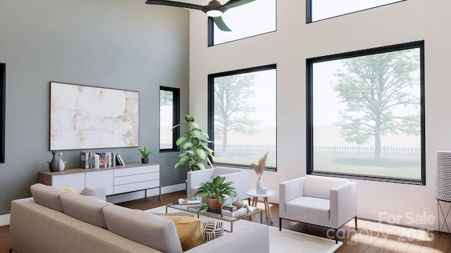 living area with a high ceiling, wood finished floors, and a ceiling fan