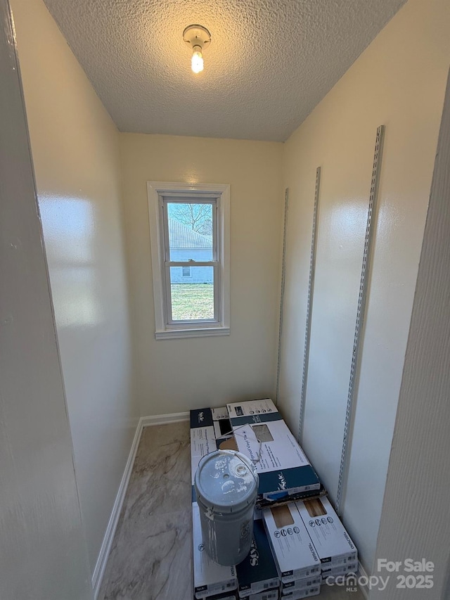 unfurnished bedroom featuring baseboards and a textured ceiling