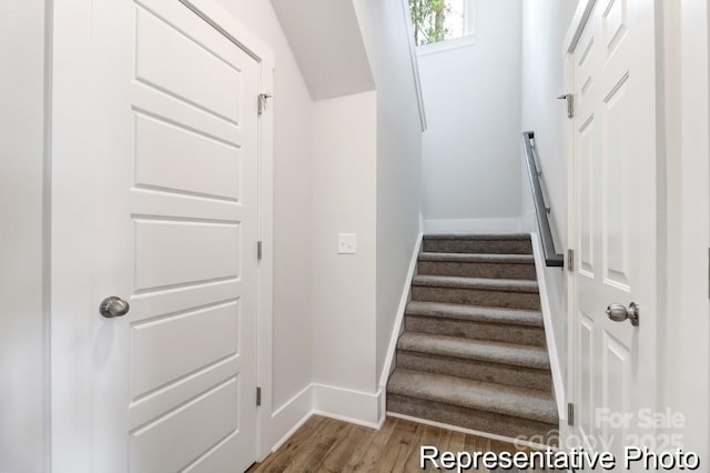 staircase with baseboards and wood finished floors