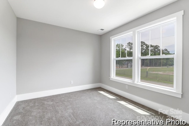 unfurnished room featuring carpet flooring, visible vents, and baseboards