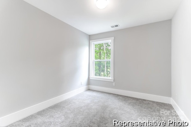 empty room featuring carpet, visible vents, and baseboards