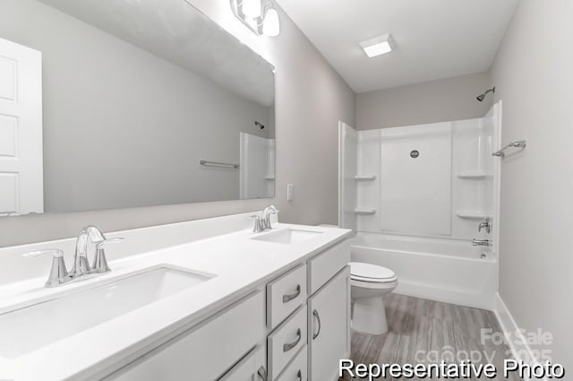 full bathroom with a sink, toilet, double vanity, and shower / bathtub combination