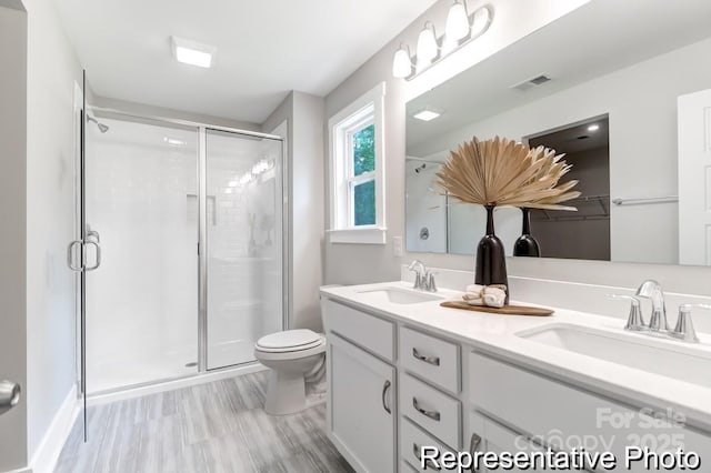 full bath with a shower stall, toilet, visible vents, and a sink