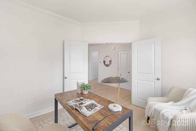 living room featuring baseboards, light wood-style floors, and crown molding