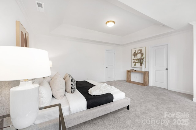 bedroom featuring carpet flooring, crown molding, visible vents, and a raised ceiling