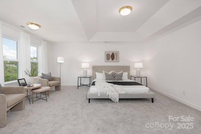 carpeted bedroom featuring a tray ceiling, visible vents, baseboards, and ornamental molding