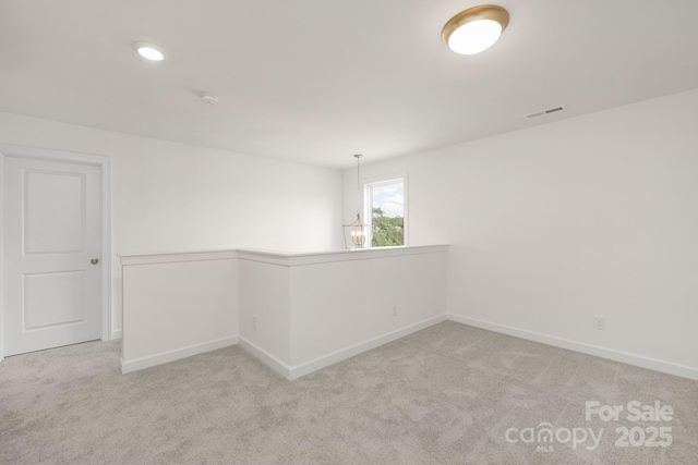 carpeted spare room with baseboards and visible vents