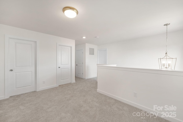 spare room featuring recessed lighting, baseboards, visible vents, a chandelier, and light colored carpet