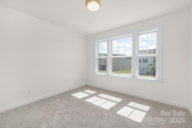 spare room with light colored carpet and baseboards