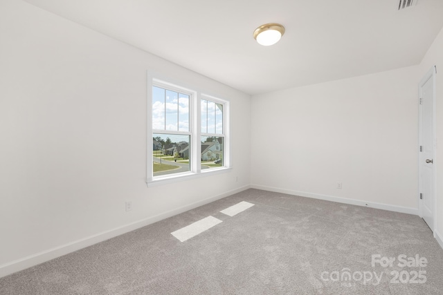 empty room with baseboards and light carpet