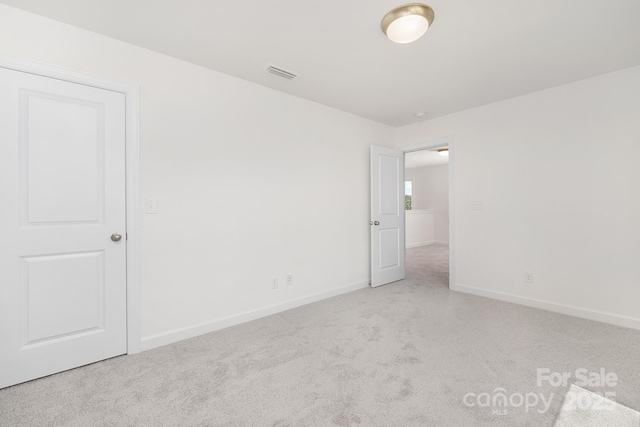 spare room with baseboards, carpet flooring, and visible vents