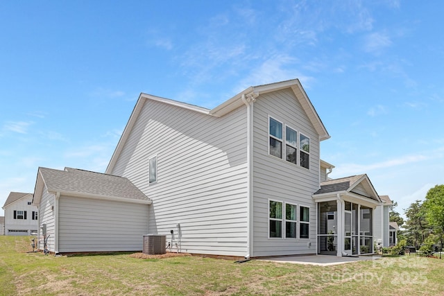 rear view of house with a lawn, a patio area, a sunroom, and central air condition unit
