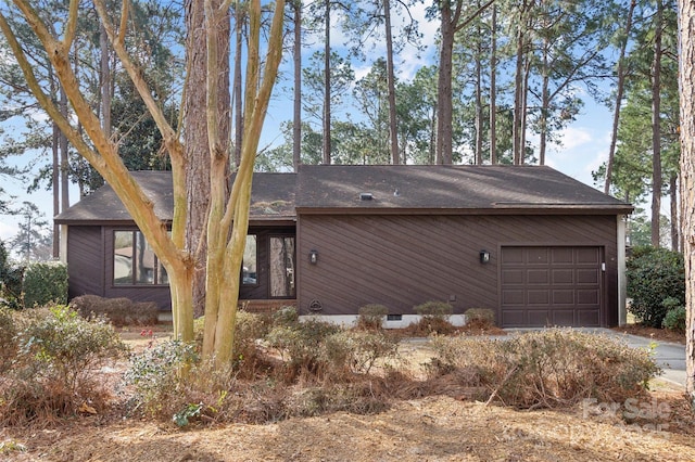 view of front of house featuring a garage and roof with shingles