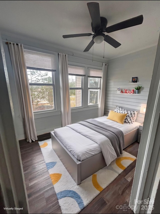 bedroom with crown molding, wood finished floors, and ceiling fan