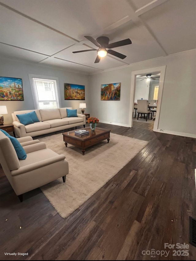 living area featuring dark wood finished floors, baseboards, ceiling fan, and ornamental molding