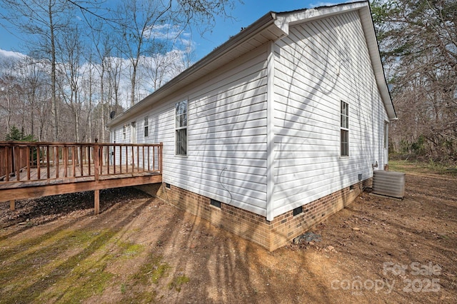 view of side of home featuring a wooden deck, cooling unit, and crawl space