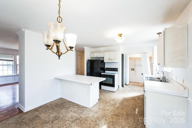 kitchen featuring a peninsula, freestanding refrigerator, a sink, range with electric stovetop, and a notable chandelier