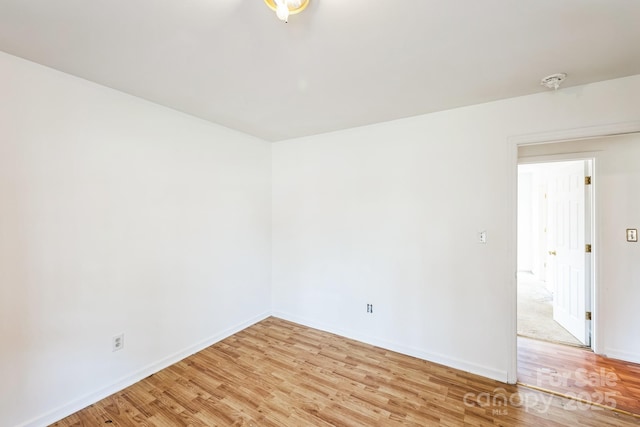 unfurnished room with light wood finished floors and baseboards