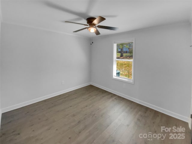 empty room featuring baseboards, wood finished floors, ceiling fan, and ornamental molding