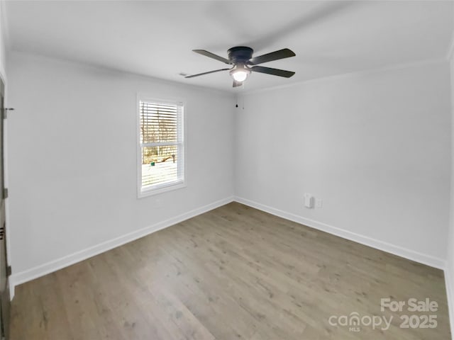 spare room with wood finished floors, baseboards, and ceiling fan